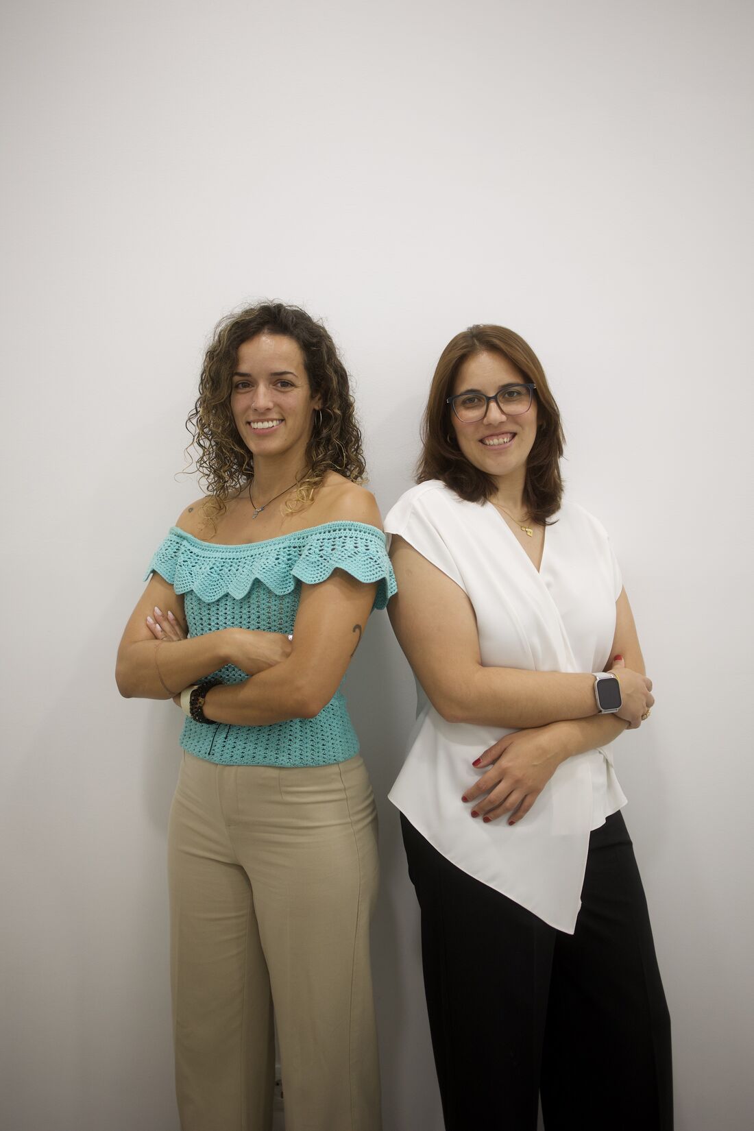 Duas colaboradoras junto à parede da Companhia da Saúde